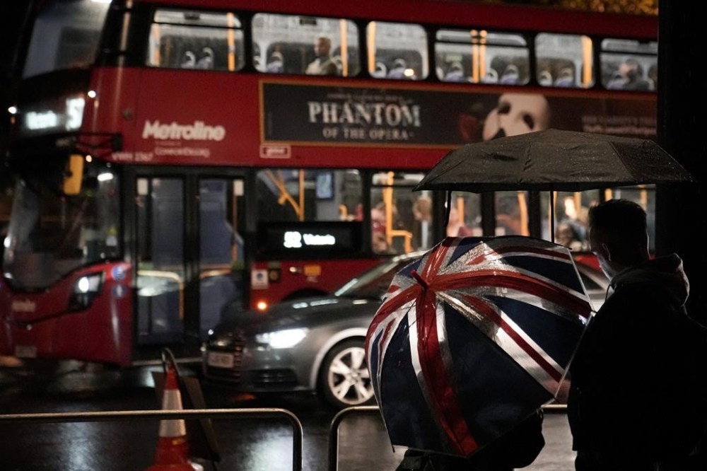 People stand after the State Hearse carrying the coffin of Queen Elizabeth II passed them on the way to Buckingham Palace in London, Tuesday, Sept. 13, 2022. Queen Elizabeth II, Britain's longest-reigning monarch and a rock of stability across much of a turbulent century, died Thursday Sept. 8, 2022, after 70 years on the throne, at the age of 96. (AP Photo/Andreea Alexandru)
