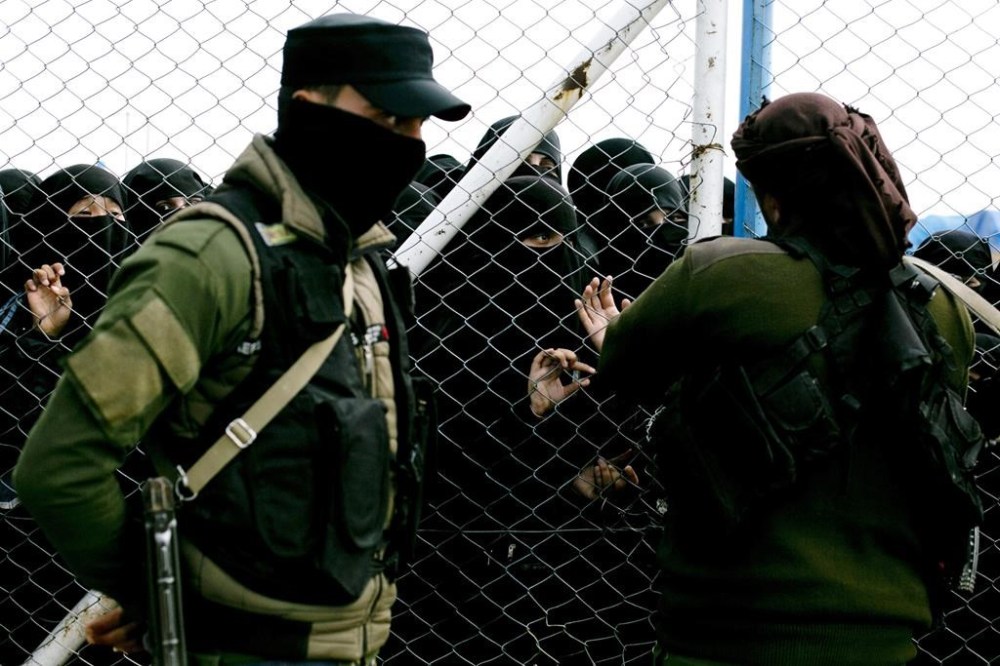 FILE - Women speak to guards at the gate that closes off the section for foreign families who lived in the Islamic State's so-called caliphate, at Al-Hol camp in Hasakeh province, Syria, March 31, 2019. U.S.-backed Syrian fighters said Saturday, Sept. 17, 2022, they have concluded a 24-day sweep at operation at a sprawling camp in northeast Syria housing tens of thousands of women and children linked to the Islamic State group. (AP Photo/Maya Alleruzzo, File)