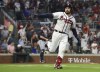 Fans cheer while Atlanta Braves' Travis d'Arnaud point to the dugout after hitting a two-run home run against the Washington Nationals during the fourth inning of a baseball game Tuesday, Sept. 20, 2022, in Atlanta. (Curtis Compton/Atlanta Journal-Constitution via AP)