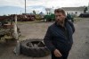 Viktor Lubinets stands next to a part of a rocket that was found on an area at the Veres farm, Novomykolaivka, eastern Ukraine, Saturday, Sept. 10, 2022. Returning to sowing and harvesting 