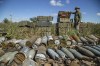 A Ukrainian soldier inspects ammunition left by the Russian troops in the recently retaken area close to Izium, Ukraine, Wednesday, Sept. 21, 2022. (AP Photo/Oleksandr Ratushniak)