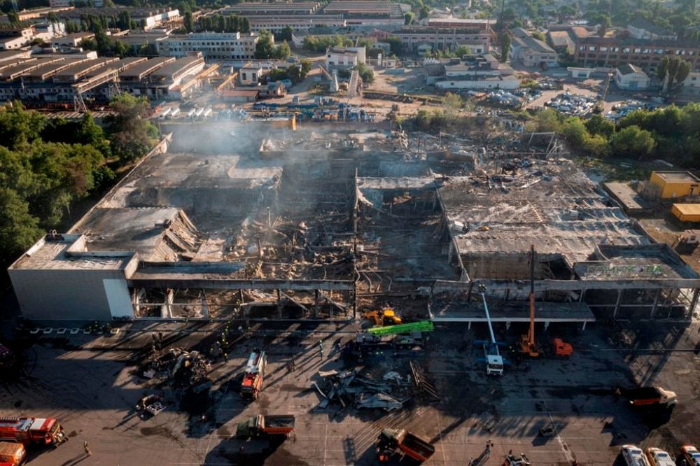 FILE - Ukrainian State Emergency Service firefighters work to take away debris at a shopping center burned after a rocket attack in Kremenchuk, Ukraine, June 28, 2022. Residents of Moscow-controlled regions in Ukraine are set to start voting Friday Sept. 23, 2022, on whether to join Russia in Kremlin-engineered referendums that set the stage for a sharp escalation of the nearly seven-month war. (AP Photo/Efrem Lukatsky, File)