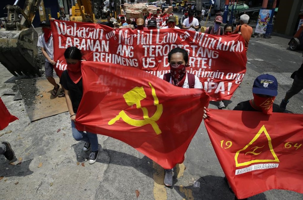 FILE - Patriotic Youths group protesters rally to commemorate the 49th anniversary of the New People's Army, the armed wing of the Communist Party of the Philippines, in Manila, Philippines on Wednesday, March 21, 2018. A Philippine court, Wednesday, Sept. 22, 2022, dismissed a government petition to declare the Communist Party of the Philippines and its armed guerrilla wing as a terrorist organization in a decision that officials vowed to appeal but was welcomed by activists who have long rejected the labeling of rebels as terrorists. (AP Photo/Aaron Favila, File)