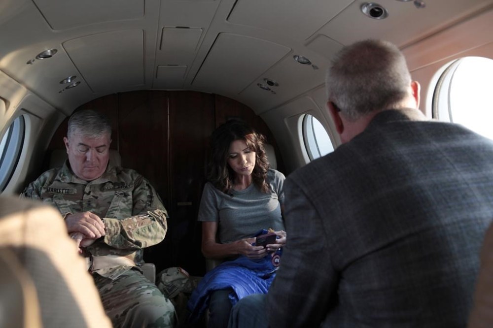 FILE - South Dakota Gov. Kristi Noem, center, checks her phone before taking off, Monday, July 26, 2021 in Pierre, S.D. Noem is under investigation for using a state-owned airplane to fly to political events and bring family members with her on trips. But the decision on whether to prosecute the Republican governor likely hinges on how a county prosecutor interprets an untested law that was passed by voters in 2006. (AP Photo/Stephen Groves)