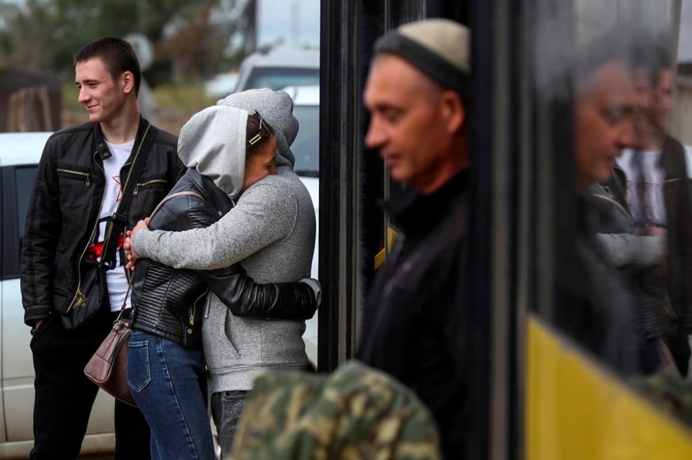 A Russian recruit and his wife kiss and hug each other outside a military recruitment center in Volgograd, Russia, Saturday, Sept. 24, 2022. Russian President Vladimir Putin on Wednesday ordered a partial mobilization of reservists to beef up his forces in Ukraine. (AP Photo)