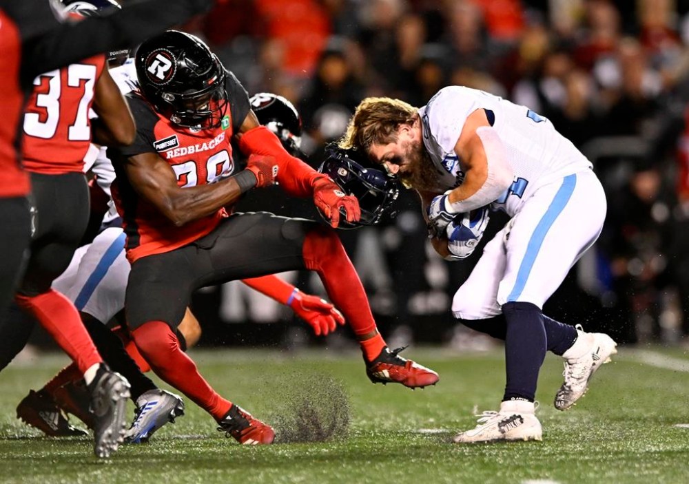 Toronto Argonauts running back AJ Ouellette (34) loses his helmet as Ottawa Redblacks linebacker Frankie Griffin (28) attempts to tackle him, during first half CFL football action in Ottawa on Saturday, Sept. 24, 2022. THE CANADIAN PRESS/Justin Tang