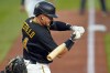 Pittsburgh Pirates' Diego Castillo begins his swing on a sacrifice fly off Chicago Cubs starting pitcher Wade Miley, driving in a run, during the first inning of the team's baseball game in Pittsburgh, Saturday, Sept. 24, 2022. (AP Photo/Gene J. Puskar)