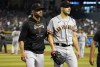 San Francisco Giants manager Gabe Kapler, left, walks pitcher Thomas Szapucki off the field after he suffered an injury in warmups during the eighth inning of a baseball game against the Arizona Diamondbacks, Saturday, Sept. 24, 2022, in Phoenix. (AP Photo/Darryl Webb)