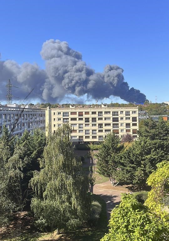 Smoke rises from a warehouse blaze at a produce market in Paris' southern suburbs, Sunday, Sept. 25, 2022. A billowing column of dark smoke towered over Paris on Sunday from a warehouse blaze at a massive produce market that supplies the French capital and surrounding region with much of its fresh food and bills itself as the largest of its kind in the world. (Martin Rouger via AP)