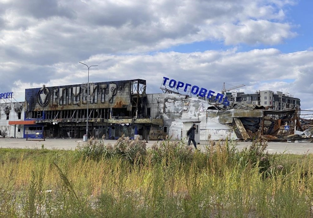 A man walks by a destroyed shopping center in Bucha, Ukraine, on Sunday, Sept. 25, 2022. Heavy fighting took place in the city in during the initial phase of Russia’s invasion of Ukraine. (AP Photo Karl Ritter)