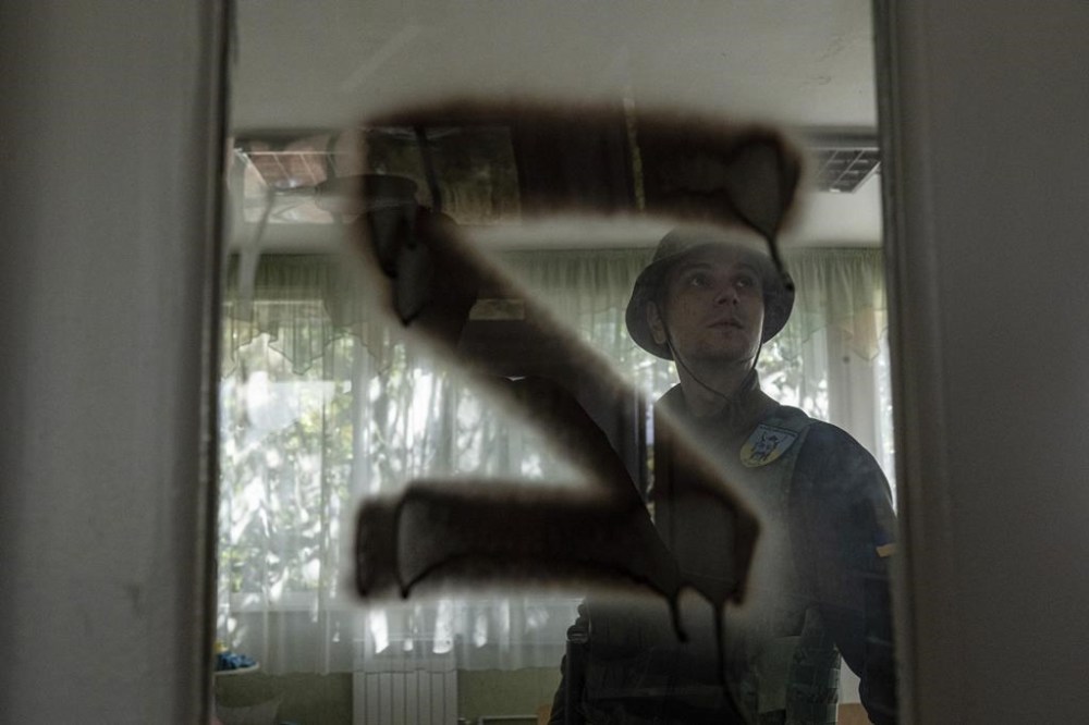 A Ukrainian serviceman inspects a kindergarten classroom with a sign