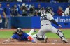Toronto Blue Jays first baseman Vladimir Guerrero Jr. (27)slides safely into home plate past New York Yankees catcher Jose Trevino (39) during fourth inning American League MLB baseball action in Toronto on Monday, September 26, 2022. THE CANADIAN PRESS/Nathan Denette