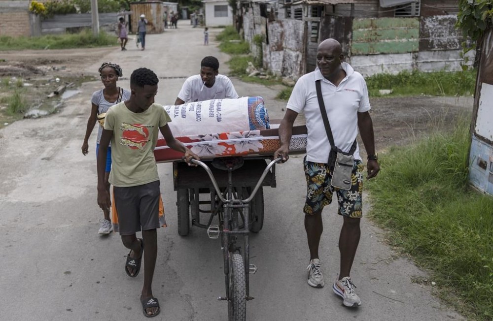 Residents of the El Fanguito neighborhood move their belongings to a safe place as they prepare for the arrival of Hurricane Ian, in Havana, Cuba, Monday, Sept. 26, 2022. Hurricane Ian was growing stronger as it approached the western tip of Cuba on a track to hit the west coast of Florida as a major hurricane as early as Wednesday. (AP Photo/Ramon Espinosa)