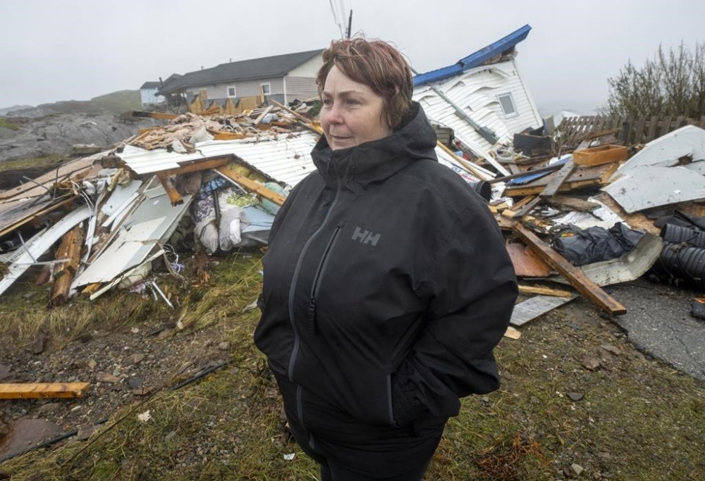 Paula Keeping stands in the remains of her house that was destroyed by hurricane Fiona in Burnt Islands, Newfoundland and Labrador on Tuesday September 27, 2022. Fiona left a trail of destruction across much of Atlantic Canada, stretching from Nova Scotia's eastern mainland to Cape Breton, Prince Edward Island and southwestern Newfoundland. THE CANADIAN PRESS/Frank Gunn