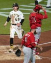 Pittsburgh Pirates' Jack Suwinski (65) scores one of three runs on a double by Miguel Andujar off Cincinnati Reds relief pitcher Buck Farmer (46) during the seventh inning of a baseball game in Pittsburgh, Tuesday, Sept. 27, 2022. (AP Photo/Gene J. Puskar)