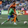 Seattle Sounders FC forward Fredy Montero (12) tries to fight through FC Cincinnati midfielder Matt Miazga during the first half of an MLS soccer game, Tuesday, Sept. 27, 2022 in Seattle. (Jennifer Buchanan/The Seattle Times via AP)