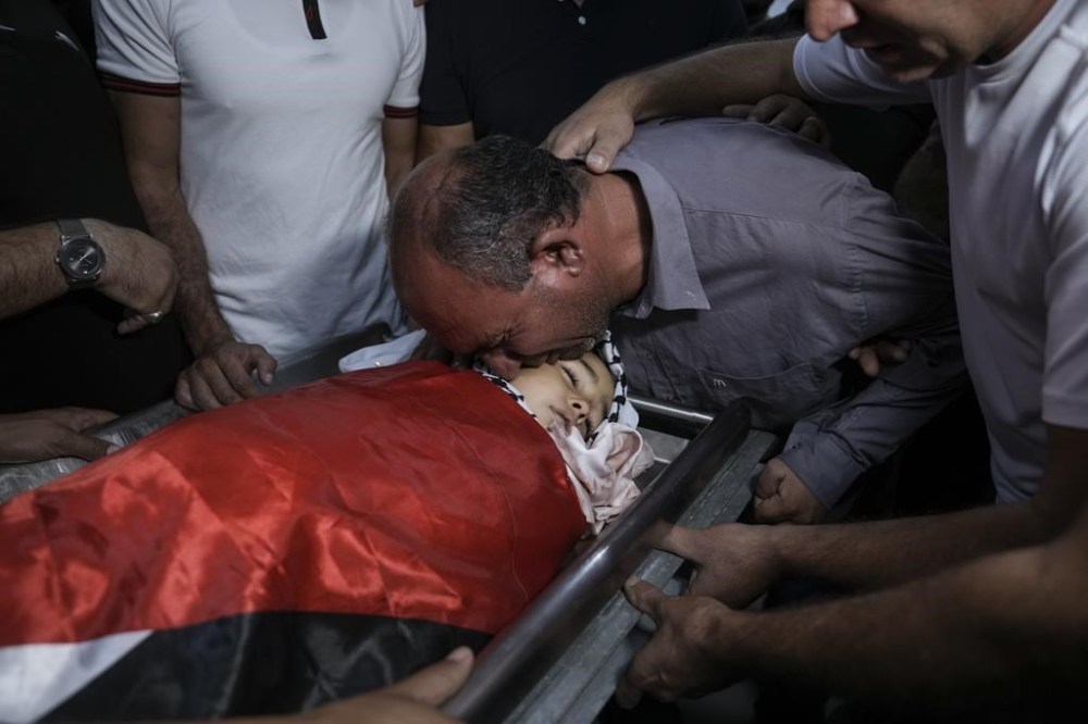 Father of 7-year-old Palestinian boy Rayan Suleiman, kisses his body at a hospital in the West Bank village of Beit Jala just before his funeral Friday, Sept. 30, 2022. The U.S. State Department has called on Israel to open a