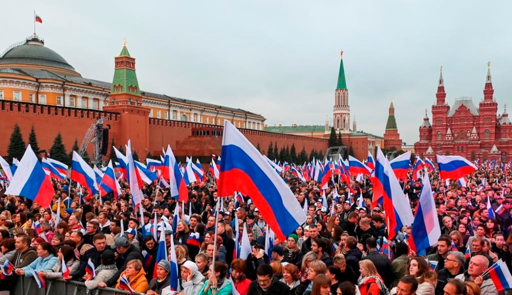 People gather during celebrations marking the incorporation of regions of Ukraine to join Russia in Red Square with the Kremlin Wall and the Historical Museum in the background in Moscow, Russia, Friday, Sept. 30, 2022. The signing of the treaties making the four regions part of Russia follows the completion of the Kremlin-orchestrated