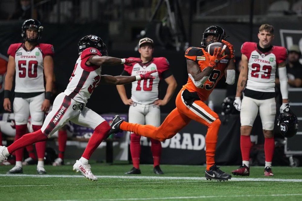 B.C. Lions' Dominique Rhymes, right, makes the reception as Ottawa Redblacks' Brandin Dandridge defends during the first half of CFL football game in Vancouver, on Friday, September 30, 2022. THE CANADIAN PRESS/Darryl Dyck
