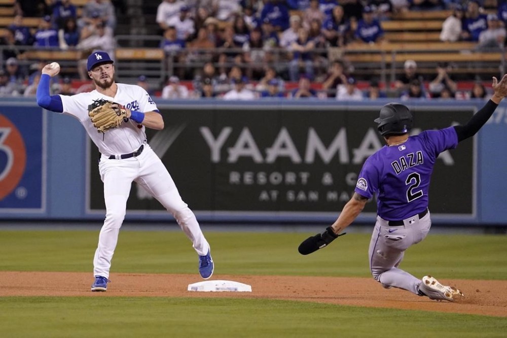 Colorado Rockies' Yonathan Daza, right, is forced out at second by Los Angeles Dodgers second baseman Gavin Lux as Lux throws out Jose Iglesias at first during the first inning of a baseball game Friday, Sept. 30, 2022, in Los Angeles. (AP Photo/Mark J. Terrill)