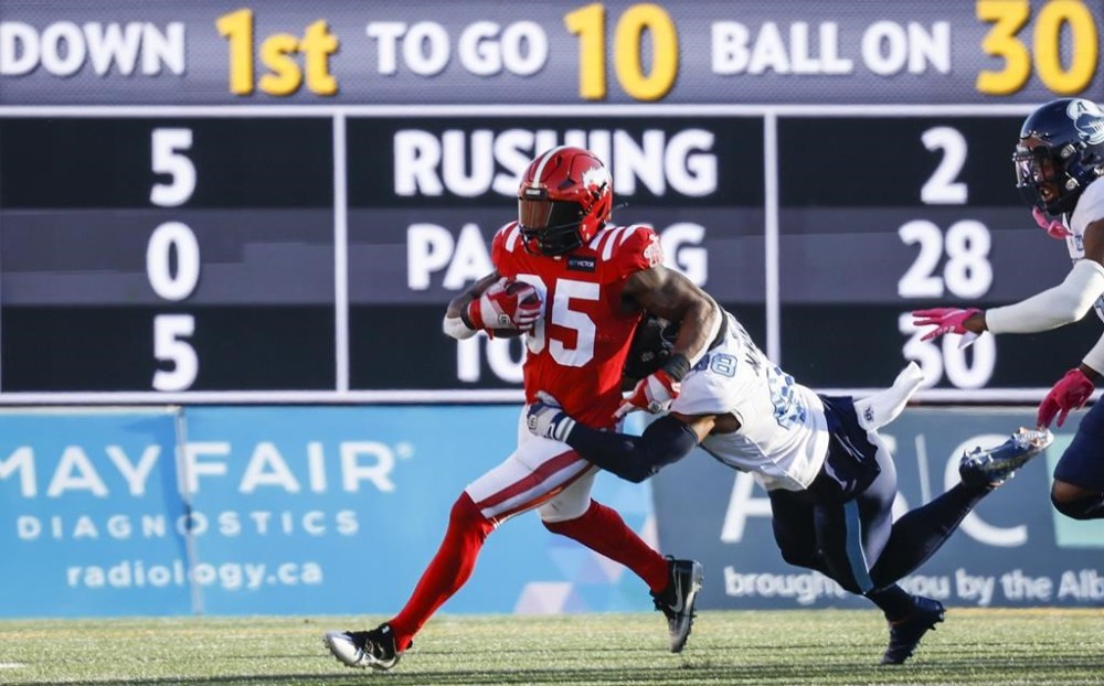 Toronto Argonauts linebacker Wynton McManis, right, brings down Calgary Stampeders running back Ka'Deem Carey during first half CFL football action in Calgary, Saturday, Oct. 1, 2022.THE CANADIAN PRESS/Jeff McIntosh