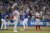 Toronto Blue Jays' Whit Merrifield (1) celebrates as he takes third base on a throwing error by Boston Red Sox catcher Connor Wong in the fourth inning of their American League MLB baseball game in Toronto on Sunday, October 2, 2022. THE CANADIAN PRESS/Cole Burston