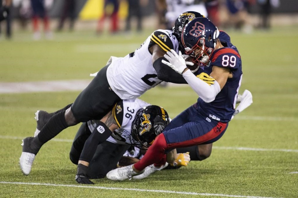 Montreal Alouettes wide receiver Fabian Guerra (89) is hit by Hamilton Tiger-Cats defensive back Alden Darby Jr. (22) during second half exhibition CFL football action in Hamilton on Saturday, May 28, 2022. Darby Jr. is back with the Winnipeg Blue Bombers. The Bombers acquired Darby from the Hamilton Tiger-Cats on Tuesday for defensive end Cedric Wilcots II. CANADIAN PRESS/Nick Iwanyshyn