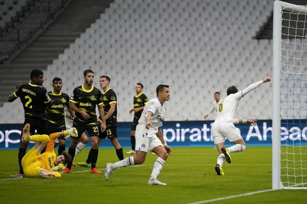 Marseille's Leonardo Balerdi, right, celebrates after scoring his side's third goal during the Champions League group D soccer match between Marseille and Sporting at the Velodrome stadium in Marseille, southern France, Tuesday, Oct. 4, 2022. (AP Photo/Daniel Cole)