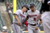 Minnesota Twins' Jose Miranda, left, pats Luis Arraez on the backside as Miranda pinch-runs for Arraez during the third inning of a baseball game against the Chicago White Sox Wednesday, Oct. 5, 2022, in Chicago. (AP Photo/Nam Y. Huh)