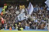 Manchester City supporters waves flags during the English Premier League soccer match between Manchester City and Manchester United at Etihad stadium in Manchester, England, Sunday, Oct. 2, 2022. (AP Photo/Rui Vieira)