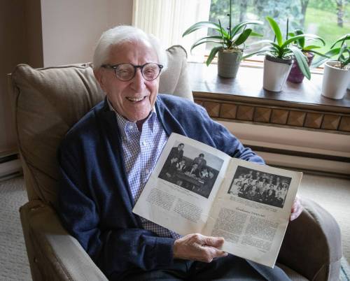 JESSICA LEE / WINNIPEG FREE PRESS
                                Neil Fast with a yearbook photo of him and his graduating class seventy-seven years ago, when he was one of the first 20 students to attend Mennonite Brethren Collegiate Institute.