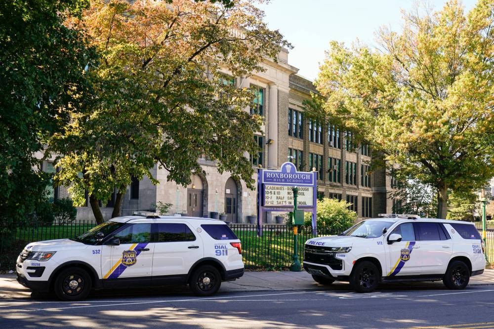 Matt Rourke / The Associated Press
Police vehicles are parked at Roxborough High School near where multiple people were shot in Philadelphia on Wednesday.