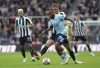 Brentford's Bryan Mbeumo, front, and Newcastle United's Dan Burn battle for the ball during the English Premier League soccer match between Newcastle United and Brentford at St James' Park, Newcastle upon Tyne, England, Saturday Oct. 8, 2022. (Owen Humphreys/PA via AP)
