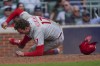 Philadelphia Phillies first baseman Rhys Hoskins (17) scores on a Philadelphia Phillies right fielder Nick Castellanos (8) single during the fourth inning in Game 1 of a National League Division Series baseball game, Tuesday, Oct. 11, 2022, in Atlanta. (AP Photo/John Bazemore)