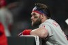Philadelphia Phillies designated hitter Bryce Harper (3) watches play from the dugout during the seventh inning in Game 2 of baseball's National League Division Series between the Atlanta Braves and the Philadelphia Phillies, Wednesday, Oct. 12, 2022, in Atlanta. (AP Photo/John Bazemore)