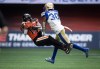 B.C. Lions' Dominique Rhymes, left, makes a reception as Winnipeg Blue Bombers' Winston Rose defends during the first half of CFL football game in Vancouver, on July 9, 2022. THE CANADIAN PRESS/Darryl Dyck