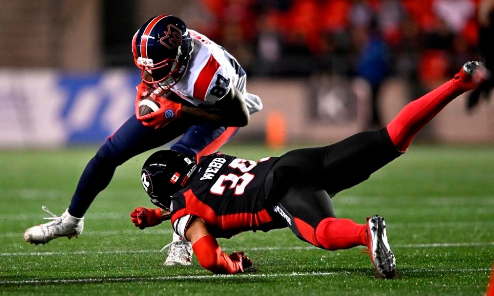 Montreal Alouettes wide receiver Eugene Lewis (87) tries to evade the tackle of Ottawa Redblacks defensive back Damon Webb (34) during first half CFL football action in Ottawa on Friday, Oct. 14, 2022. THE CANADIAN PRESS/Justin Tang