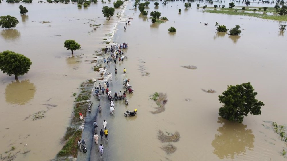 FILE- People walk through floodwaters after heavy rainfall in Hadeja, Nigeria, Monday, Sept 19, 2022. Officials in Nigeria say the death toll from this year's flooding has now risen to 603. Authorities have called the floods the country's worst in more than a decade, blaming the disaster on unusually heavy rainfall and the release of excess water from the Lagdo dam in neighboring Cameroon. (AP Photo, File)