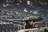 Baseball fans wait out a rain delay for Game 5 of an American League Division baseball series between the New York Yankees and the Cleveland Guardians, Monday, Oct. 17, 2022, in New York. (AP Photo/Seth Wenig)