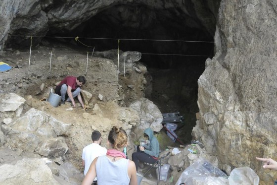 Researchers excavate a cave in the mountains of Siberia, Russia. (Bence Viola via The Associated Press)