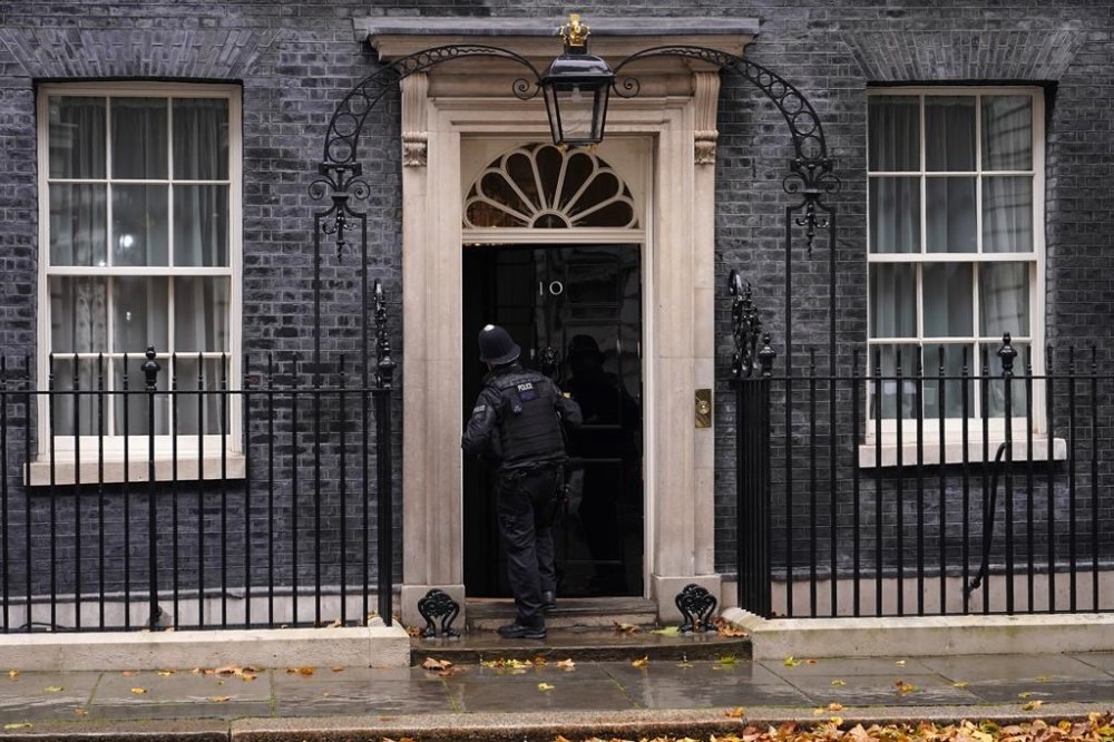 A police officer knocks on the door to 10 Downing Street in London, Thursday, Oct. 20, 2022. (AP Photo/Alberto Pezzali)