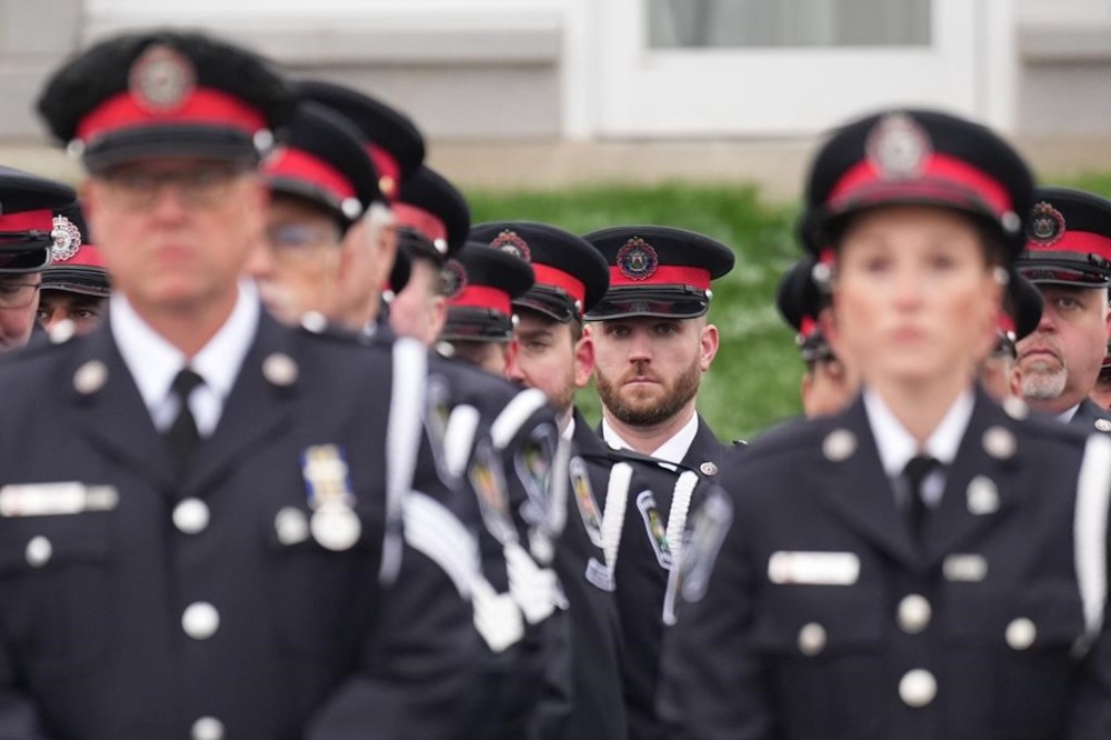 South Simcoe Police Service officers line up in a procession before the funeral service for constables Morgan Russell and Devon Northrup in Barrie, Ont., on Thursday, Oct.20, 2022. The two police officers were killed in a shooting in Innisfil, Ont., last week. THE CANADIAN PRESS/Nathan Denette