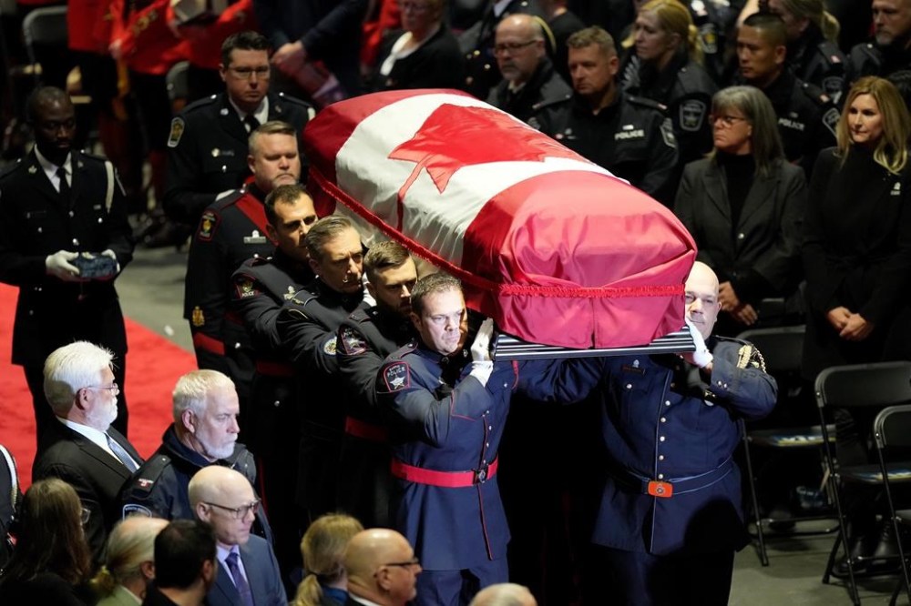 The casket of South Simcoe Police Service constable Devon Northrup is carried into a joint funeral service in Barrie, Ont., Thursday, Oct. 20, 2022. Northrup and fellow SSPS constable Morgan Russell were killed in a shooting in Innisfil, Ont., last week. THE CANADIAN PRESS/Nathan Denette