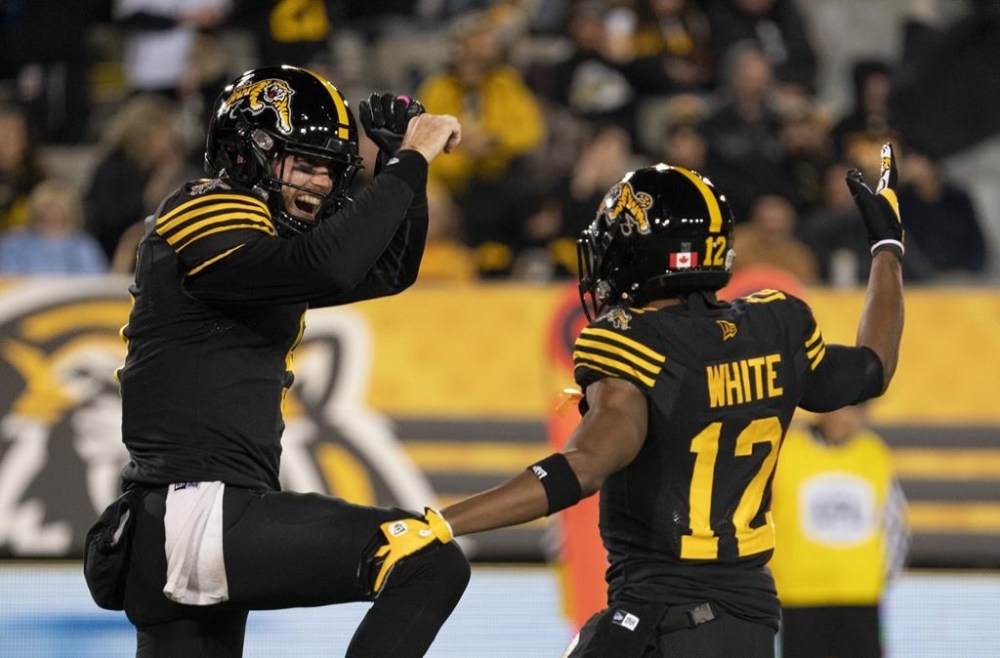 Hamilton Tiger-Cats quarterback Dane Evans (9) celebrates his touchdown with Tim White (12) during first half CFL football game action against the Saskatchewan Roughriders in Hamilton, Ont., Friday, Oct. 7, 2022. Evans and the Hamilton Tiger-Cats did more than just exorcise a few demons with last week's road win in Calgary. They also reclaimed control of their playoff destiny. THE CANADIAN PRESS/Peter Power