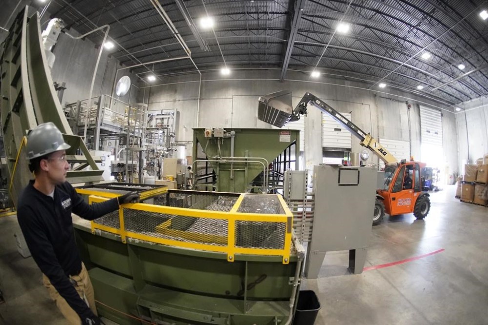 Jeremy DeBenedictis, President of Alterra Energy, left, watches as an operator moves a loading machine into position at the company to drop a scoop of ground up plastics the company receives from recycling facilities to their facility in Akron, Ohio. “Our mission is to solve plastic pollution,” said DeBenedictis, company president. “That is not just a tag line. We all truly want to solve plastic pollution.” (AP Photo/Keith Srakocic)