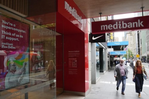 FILE - People walk past a Medibank branch in Sydney on Oct. 20, 2022. Australia on Saturday, Oct. 22, 2022 proposed tougher penalties for companies that fail to protect customers’ personal data after two major cybersecurity breaches left millions vulnerable to criminals. (AP Photo/Rick Rycroft, File)