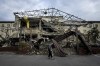 A patient walks past the surgery department which was destroyed after a Russian attack at the hospital in Izium, Ukraine, Saturday, Sept. 17, 2022. Medical staff at the Izium hospital in eastern Ukraine are fighting the memories of six deadly months under Russian occupation. They also are looking darkly ahead at the coming months without electricity. (AP Photo/Evgeniy Maloletka)
