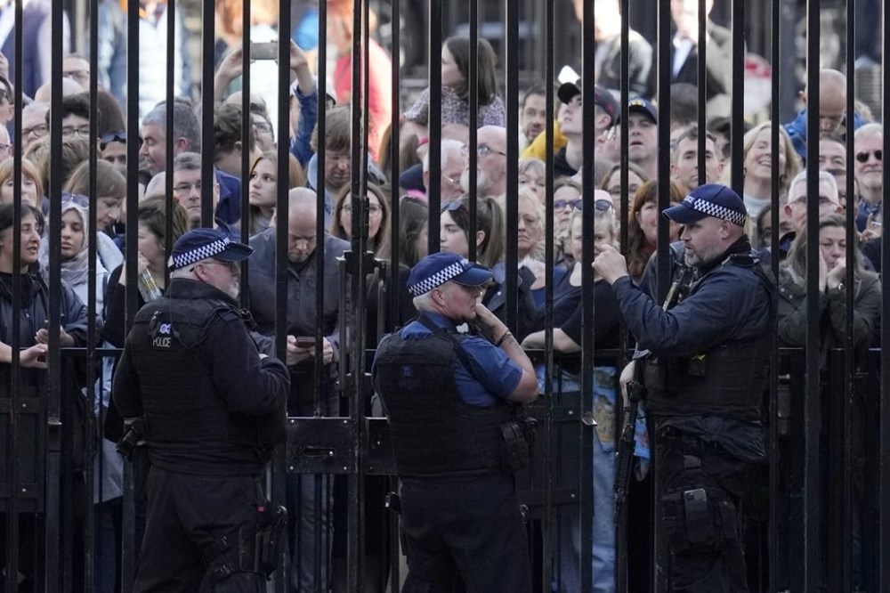 Members of the public look through the gates at Downing Street in London, Monday, Oct. 24, 2022. Former British Treasury chief Rishi Sunak is frontrunner in the Conservative Party's race to replace Liz Truss as prime minister. (AP Photo/Kirsty Wigglesworth)