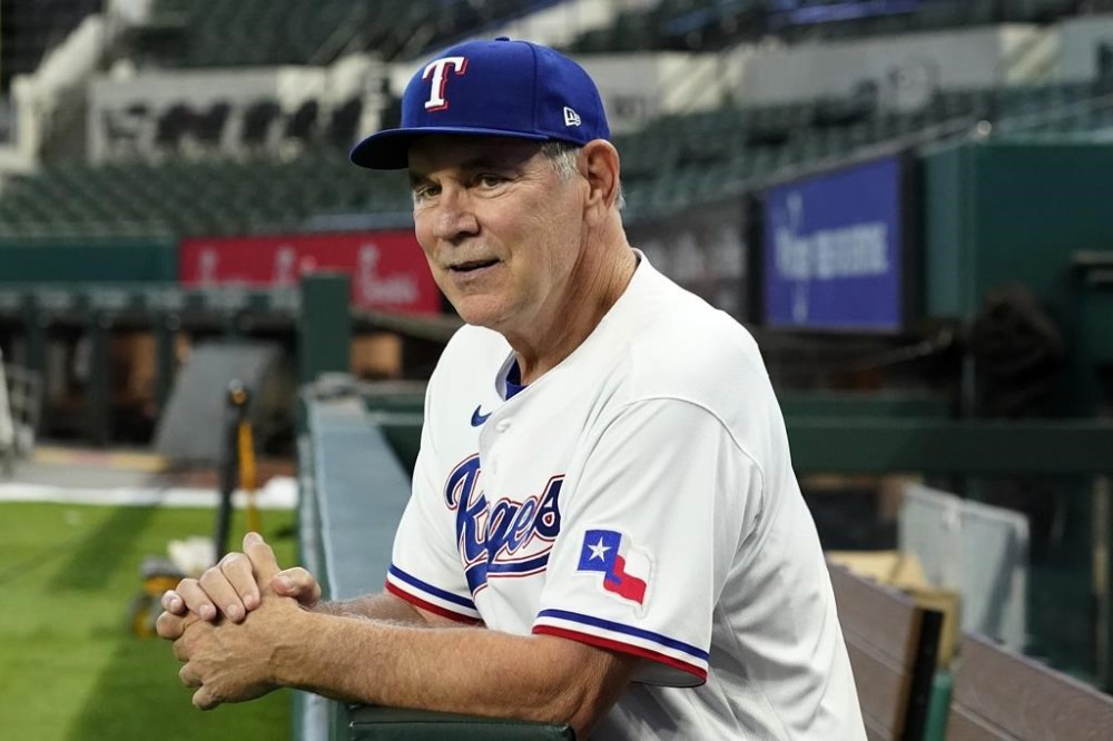 New Texas Rangers baseball team manager Bruce Bochy poses for photos in the dugout at Globe Life Field after a news conference in Arlington, Texas, Monday, Oct. 24, 2022. (AP Photo/Tony Gutierrez)