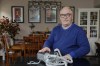 Jeffrey Reed, who experienced persistent sinus infections and two bouts of pneumonia while using a Philips CPAP machine, poses with the device at his home Thursday, Oct. 20, 2022, in Marysville, Ohio. The device is part of a massive global recall of breathing machines triggered by sound-dampening foam that can break down, releasing potentially harmful particles and chemicals. (AP Photo/Jay LaPrete)